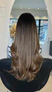 Coloration sans ammoniaque appliquée sur des cheveux brillants et en bonne santé, idéale pour un résultat naturel et respectueux de la fibre capillaire.
