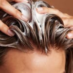 femme qui lave ses cheveux avec un shampoing hydratant