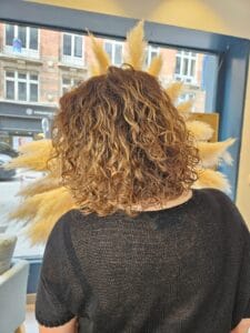 Cheveux méchés effet contouring sur cheveux bouclés – lumière subtile et harmonieuse signée La Maison du Coloriste