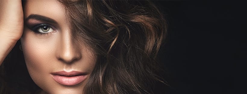 Gros plan sur cheveux bruns ondulés et brillants, résultat de soin professionnel en salon de coiffure à lille