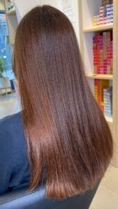 Femme brune avec balayage caramel lumineux en pleine lumière naturelle