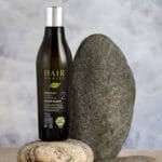 Image immersive de la gamme Hairborist présentée au cœur d’un décor botanique, avec les six flacons alignés parmi des ingrédients bruts : noix de lavage, feuilles de thé, menthe fraîche, aloe vera, et huiles essentielles. Chaque shampoing symbolise une fonction ciblée : apaisant, purifiant, protecteur, tonifiant, équilibrant ou quotidien. Cette composition transmet un message sensoriel fort autour du soin bio et de la cosmétique végétale.