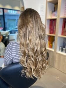 Longs cheveux wavy avec balayage miel et mèches dorées délicates