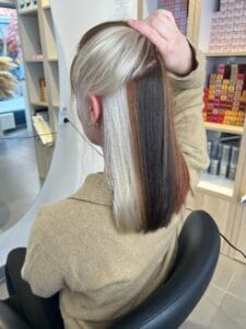 Coloration peekaboo blond et brun sous la chevelure, mèches contrastées tendance à Lille