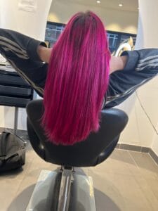 Coloration magenta intense sur cheveux longs lisses, cliente de dos au salon La Maison du Coloriste à Lille