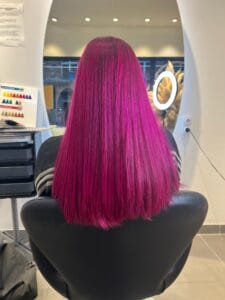Cheveux longs magenta brillant, couleur uniforme réalisée par coloriste expert à Lille
