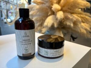 Soins capillaires vegan : aloe vera, huile de coco, avocat, beurre végétal, flacons cosmétiques et plantes médicinales.