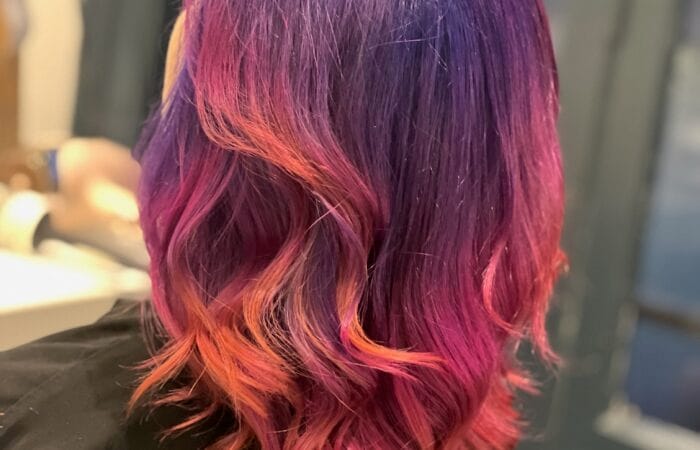 Coloration créative à Lille : cheveux violet profond avec reflets rose et pointes cuivrées