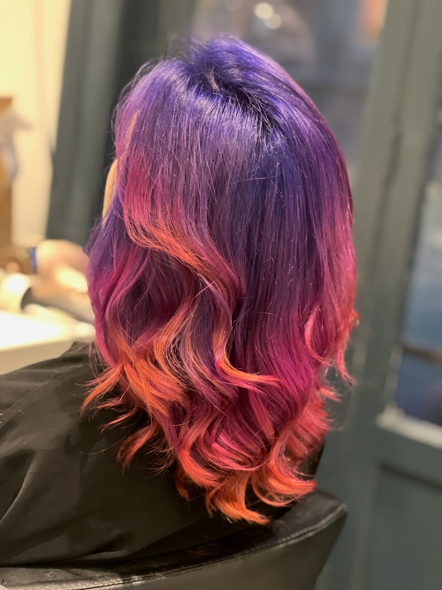 Coloration créative à Lille : cheveux violet profond avec reflets rose et pointes cuivrées