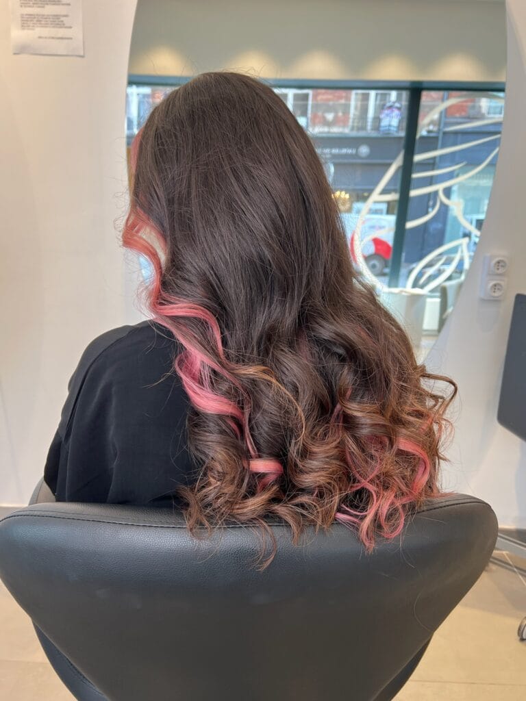 Underlight rose discret à la nuque sur cheveux marrons