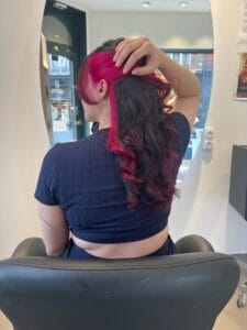 Underlight rose fuschia à la nuque sur cheveux bruns