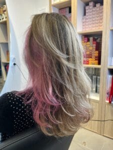 Underlights rose sous la chevelure sur cheveux blonds