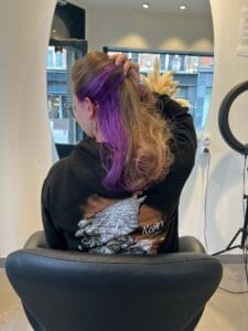 Underlight violet sur cheveux bouclés révélant une sous-couche colorée