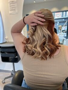 Underlight marron cheveux à la nuque, mèches colorées visibles sur cheveux bouclés